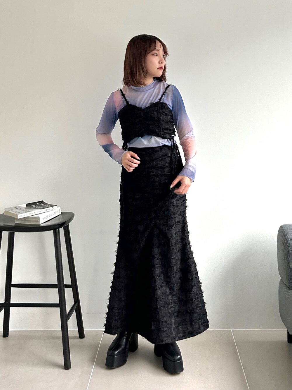 ブラック系のワンピース、ピンク系のTシャツ/カットソー、ブラック系のブーツを着用したレディースの秋コーディネートの2枚目の写真