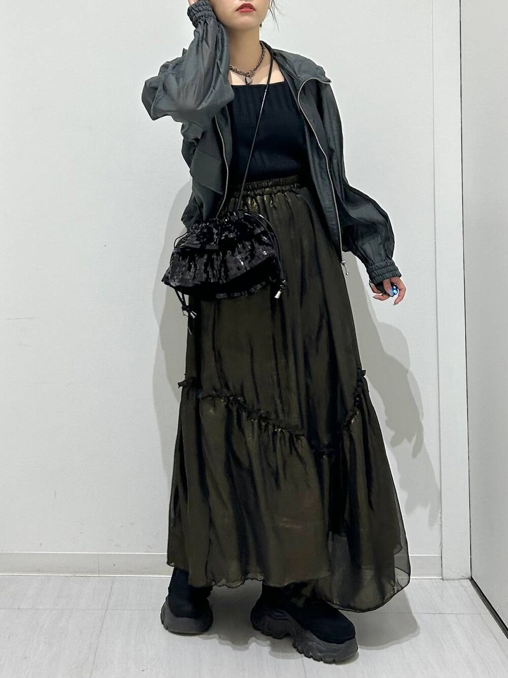 ブラック系のタンクトップ、ブラック系のスカート、グレー系のブルゾンを着用したレディースの春コーディネートの4枚目の写真