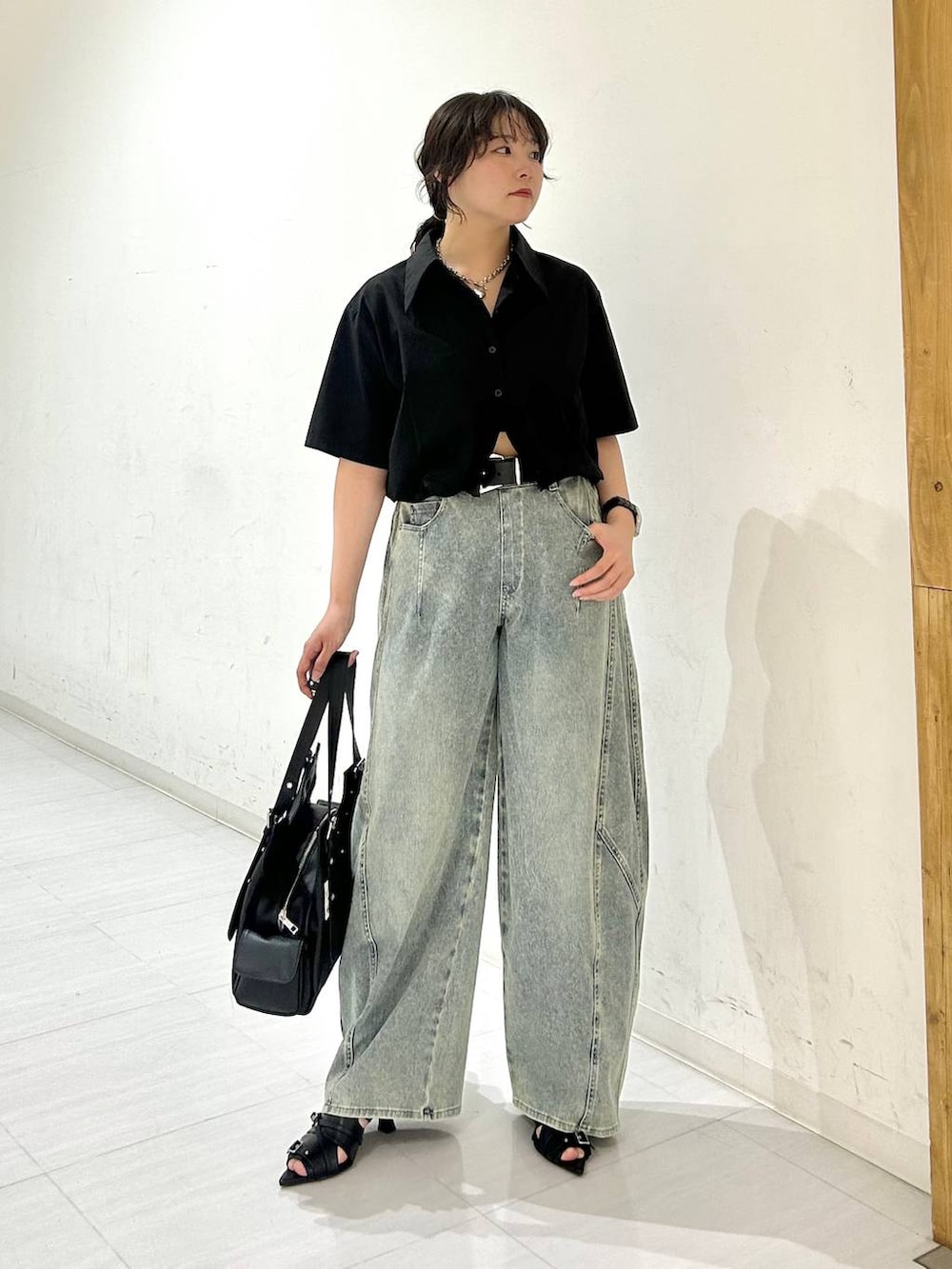 ブルー系のデニムパンツ、ブラック系のサンダル、ブラック系のベルトを着用したレディースの夏コーディネートの9枚目の写真