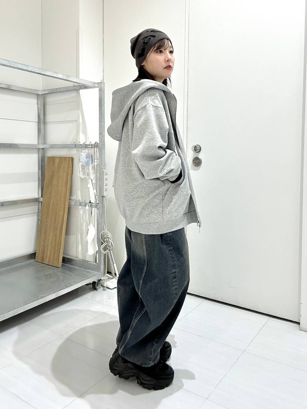 ブラック系のスニーカー、グレー系のパーカー、ブラック系のニット/セーターを着用したレディースの冬コーディネートの2枚目の写真