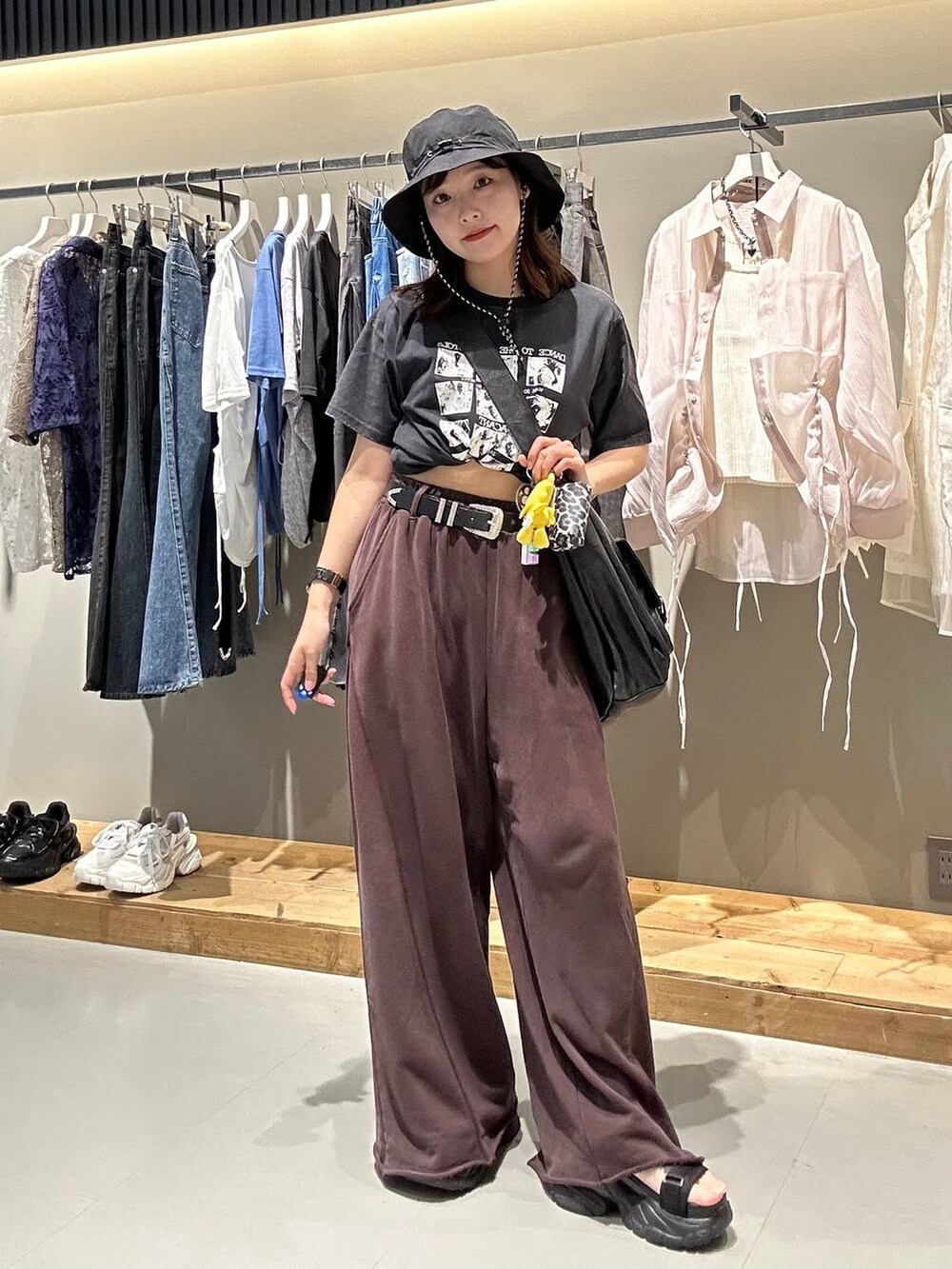 ブラウン系のスウェットパンツ、ブラック系のハットを着用したレディースの夏コーディネートの3枚目の写真