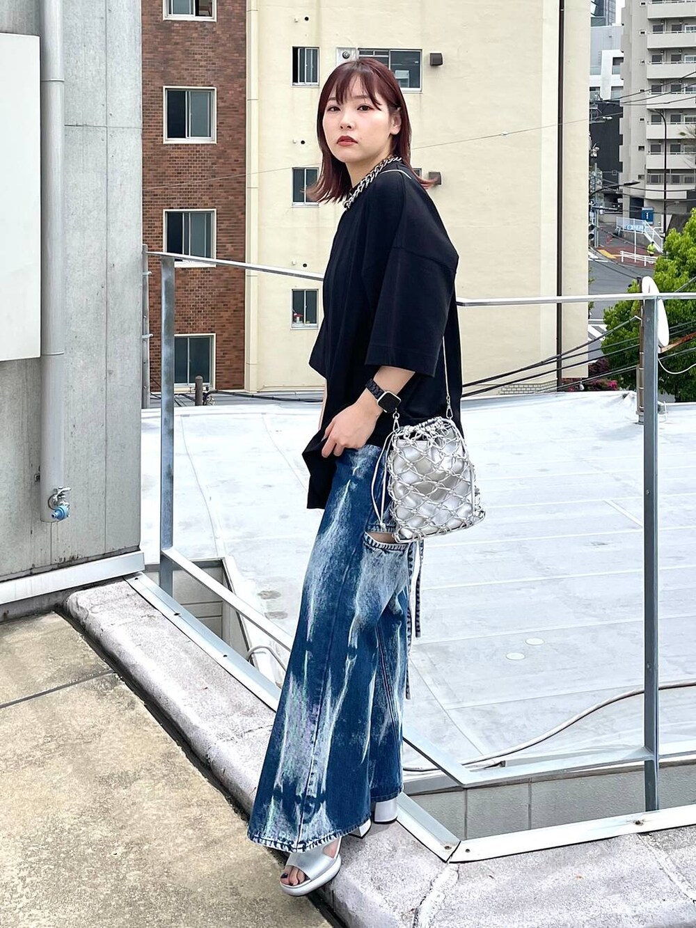 シルバー系のサンダル、シルバー系のショルダーバッグ、ブルー系のデニムパンツを着用したレディースの春コーディネートの5枚目の写真