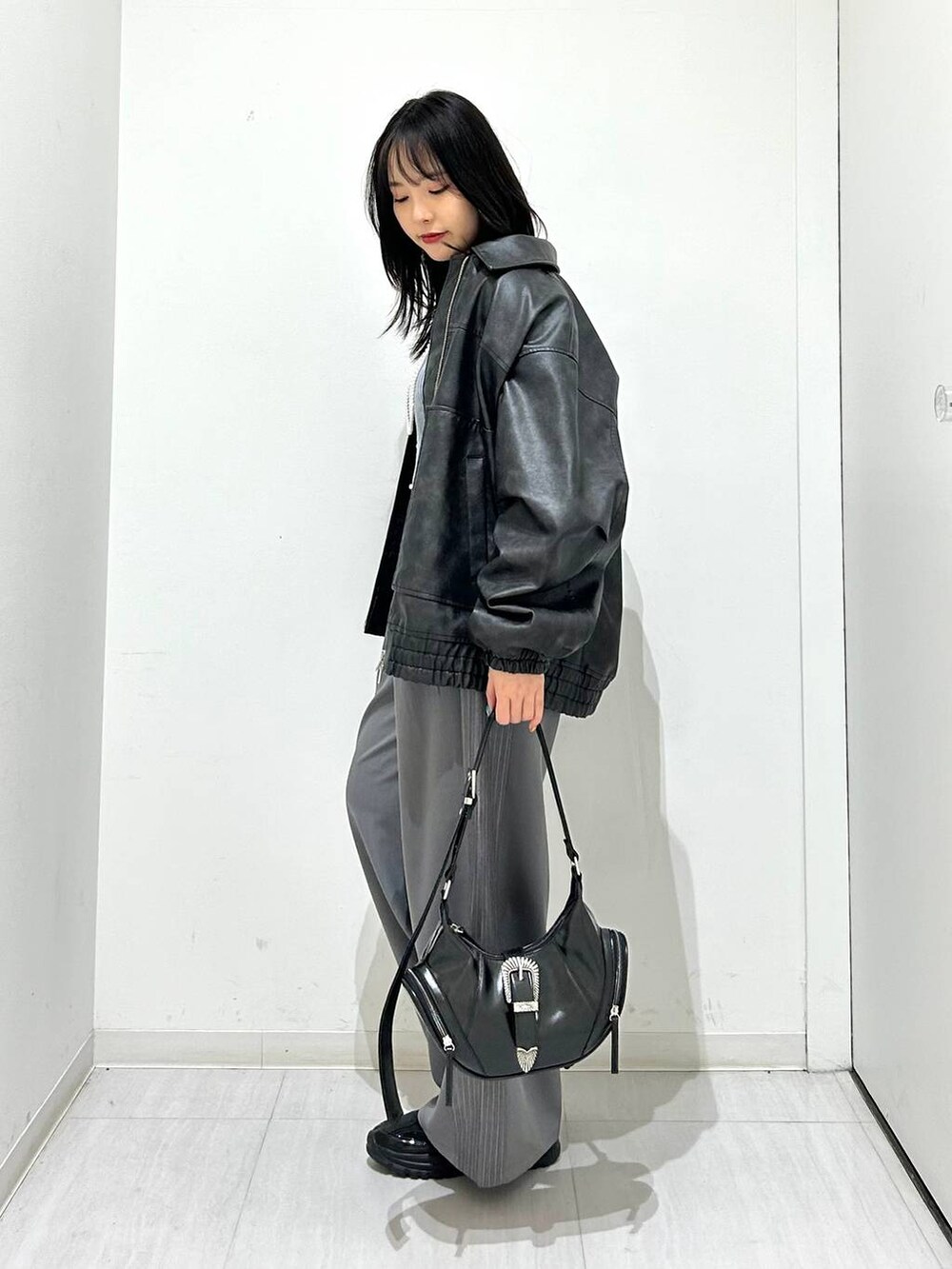 ブラック系のブルゾン、ブラック系のスニーカー、ブラック系のショルダーバッグを着用したレディースの春コーディネートの5枚目の写真