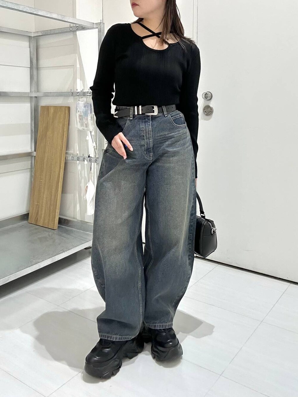 ブラック系のスニーカー、ブラック系のボストンバッグ、ブラック系のニット/セーターを着用したレディースの冬コーディネートの2枚目の写真