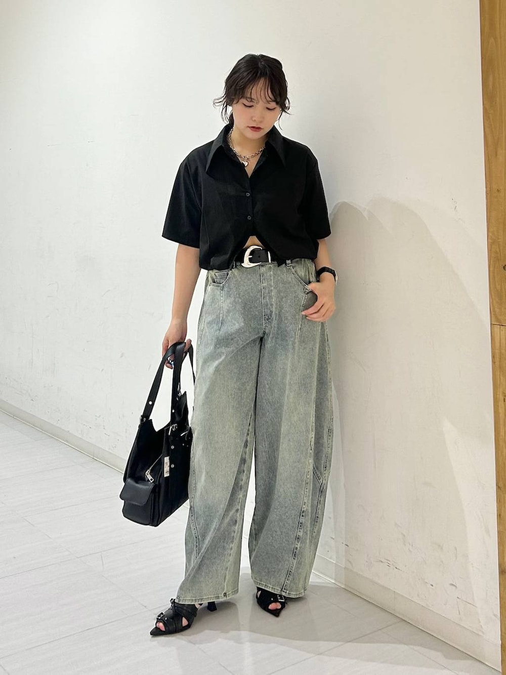 ブルー系のデニムパンツ、ブラック系のサンダル、ブラック系のベルトを着用したレディースの夏コーディネートの2枚目の写真