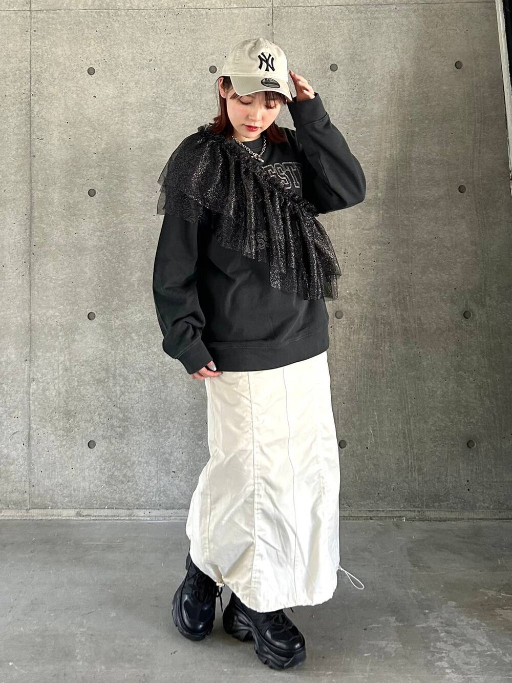 ブラック系のスニーカー、ホワイト系のスカート、ブラック系のスウェットを着用したレディースの春コーディネートの4枚目の写真