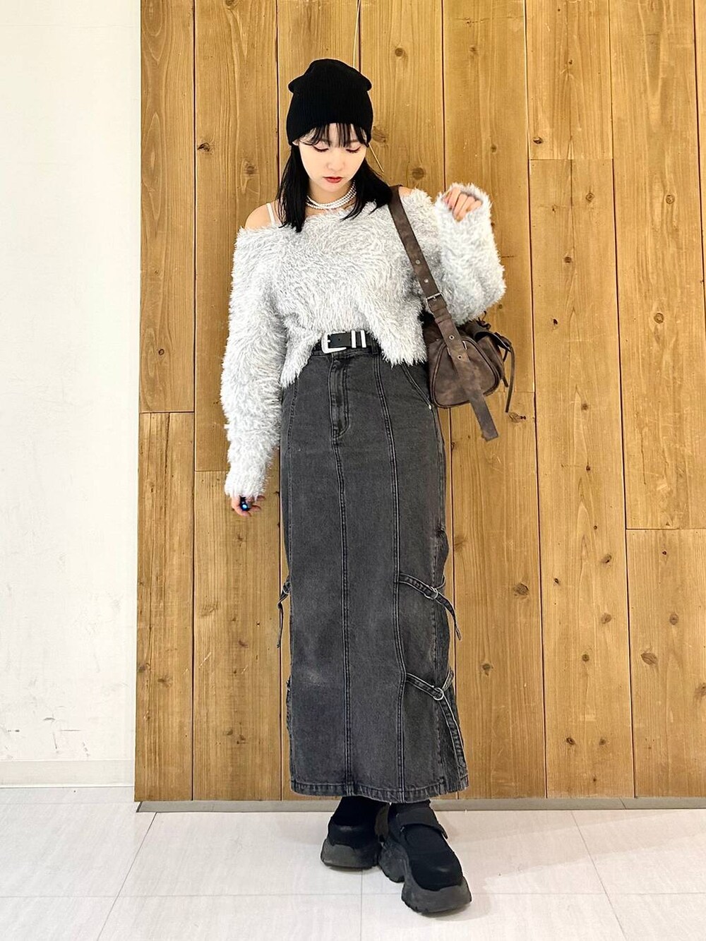 ブラウン系のショルダーバッグ、ブラック系のデニムスカート、ブラック系のスニーカーを着用したレディースの秋コーディネートの3枚目の写真