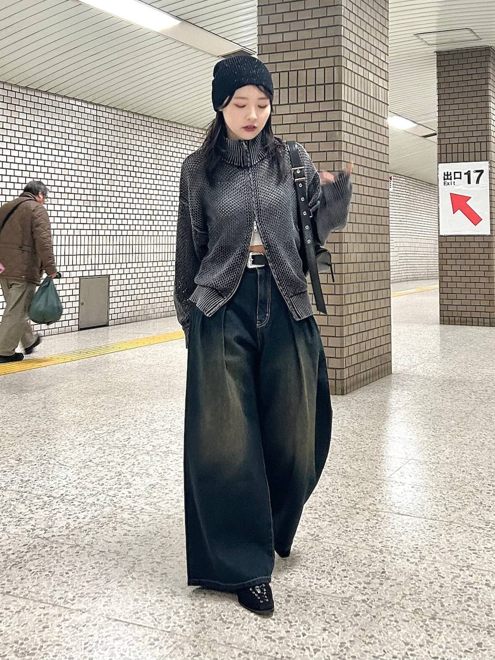 ブルー系のデニムパンツ、ブラック系のパンプス、ブラック系のショルダーバッグを着用したレディースの春コーディネートの2枚目の写真