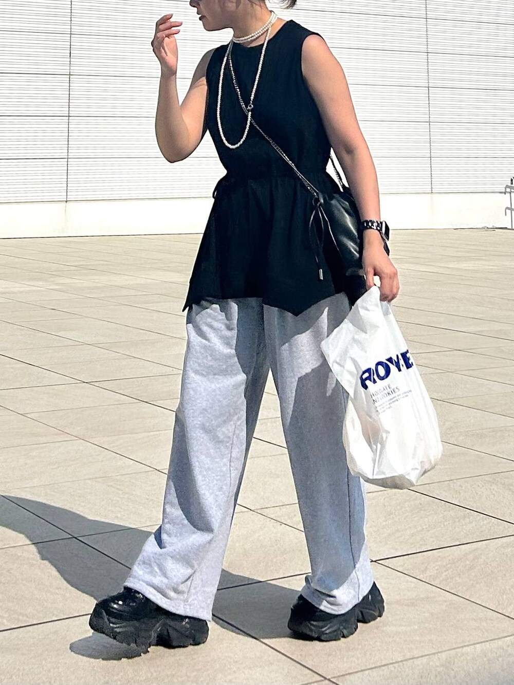 ブラック系のスニーカー、グレー系のスウェットパンツ、ブラック系のTシャツ/カットソーを着用したレディースの夏コーディネートの3枚目の写真