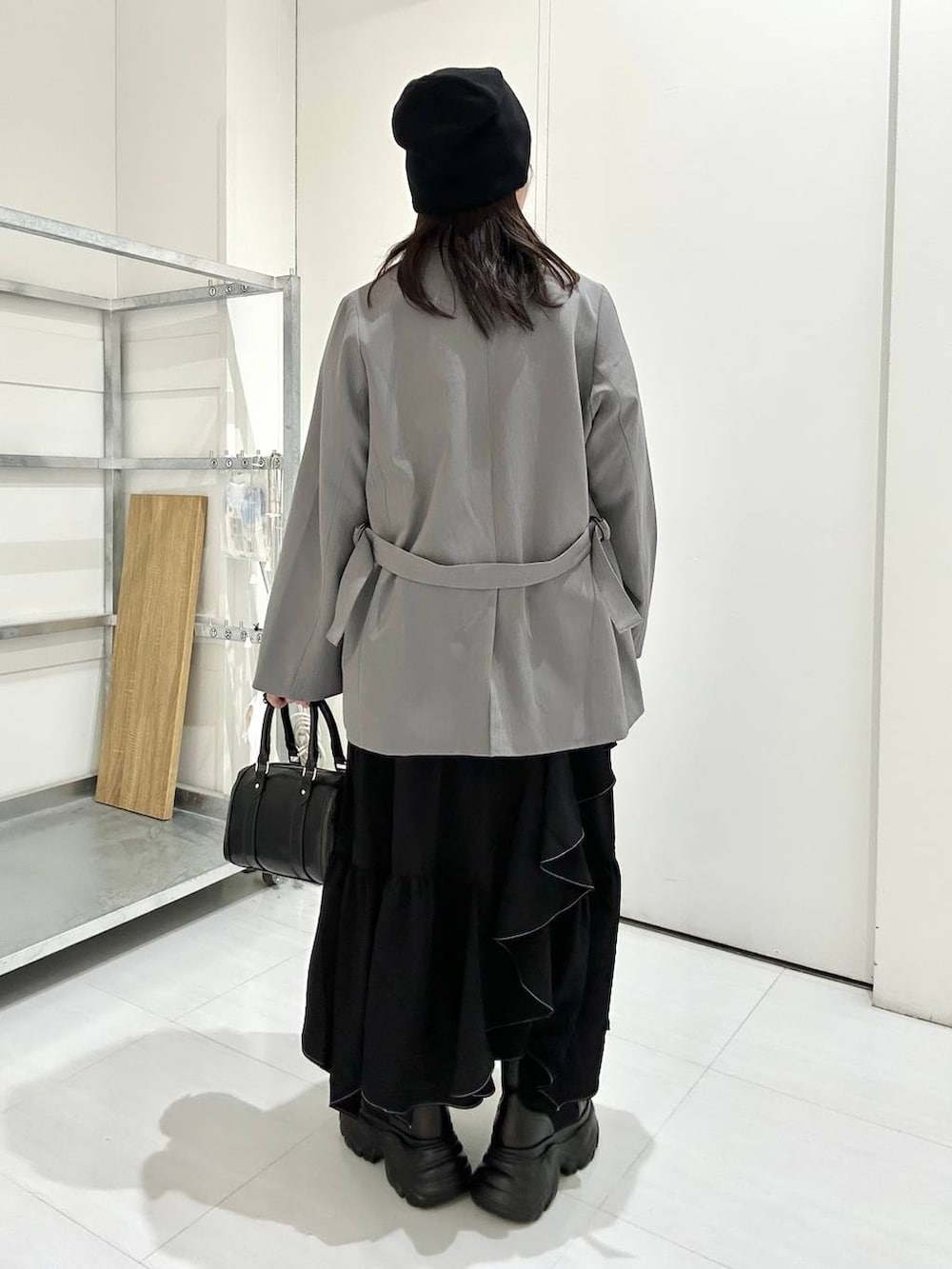 ブラック系のブーツ、グレー系のテーラードジャケット、ブラック系のスカートを着用したレディースの冬コーディネートの5枚目の写真