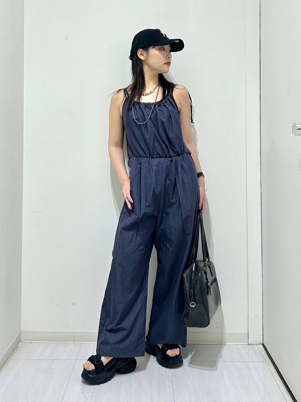 ブラック系のボストンバッグ、ブラック系のサンダル、ブラック系のキャミソールを着用したレディースの春コーディネートの4枚目の写真