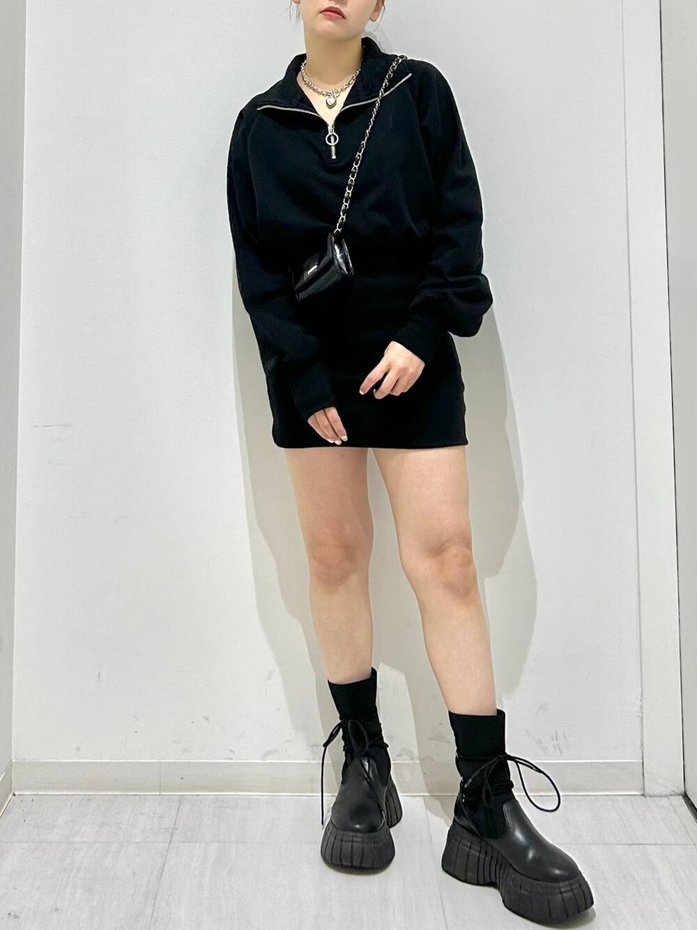 ブラック系のワンピース、ブラック系のブーツ、ブラック系のショルダーバッグを着用したレディースの冬コーディネートの2枚目の写真