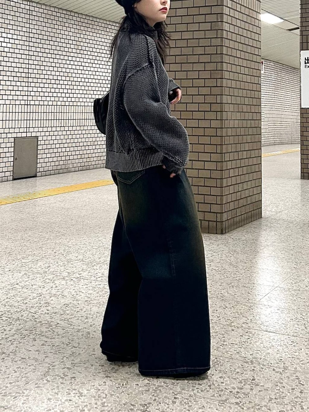 ブルー系のデニムパンツ、ブラック系のパンプス、ブラック系のショルダーバッグを着用したレディースの春コーディネートの6枚目の写真