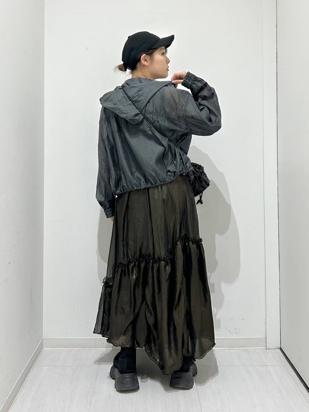 ブラック系のタンクトップ、ブラック系のスカート、グレー系のブルゾンを着用したレディースの春コーディネートの5枚目の写真