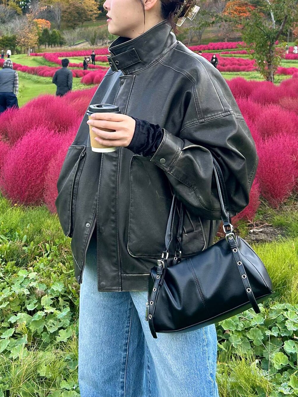 ブラック系のボストンバッグ、ブラック系のブルゾンを着用したレディースの秋コーディネートの2枚目の写真