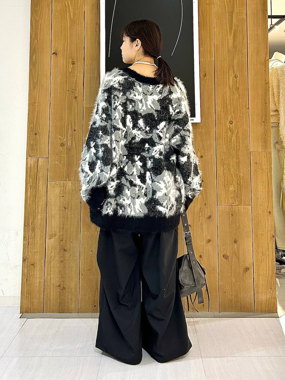 ブラック系のタンクトップ、ブラック系のパンプス、ブラック系のショルダーバッグを着用したレディースの秋コーディネートの5枚目の写真