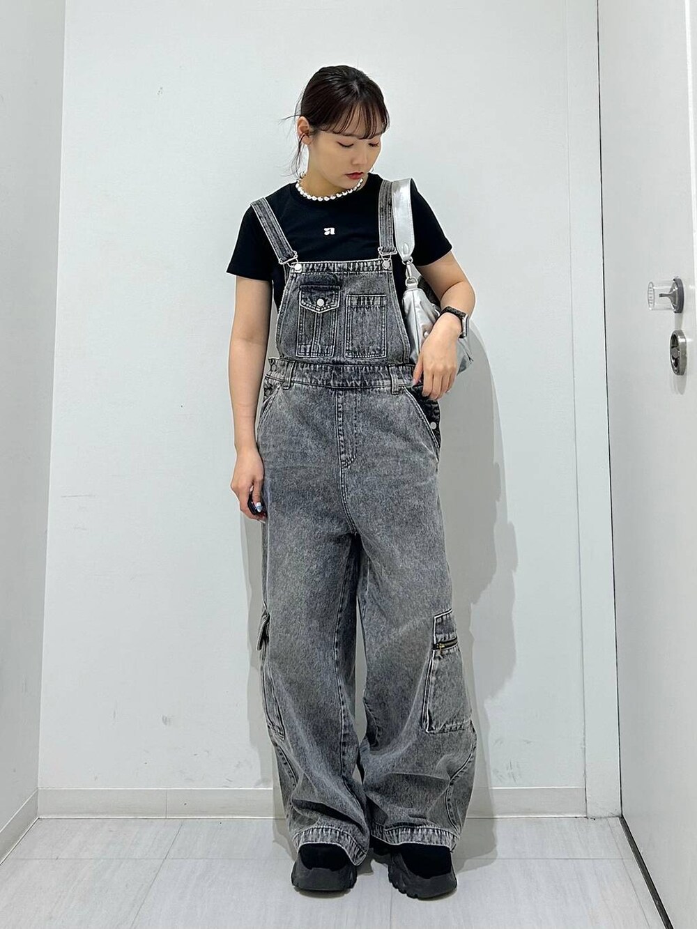 ブラック系のサロペット/オーバーオール、シルバー系のショルダーバッグ、ブラック系のTシャツ/カットソーを着用したレディースの夏コーディネートの3枚目の写真