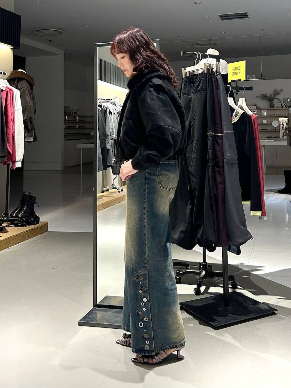 ブラック系のブルゾン、ブルー系のデニムパンツ、ブラウン系のTシャツ/カットソーを着用したレディースの秋コーディネートの5枚目の写真