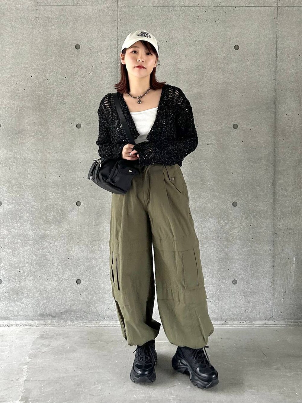 ブラック系のショルダーバッグ、ブラック系のスニーカー、グリーン系のその他パンツを着用したレディースの春コーディネートの2枚目の写真