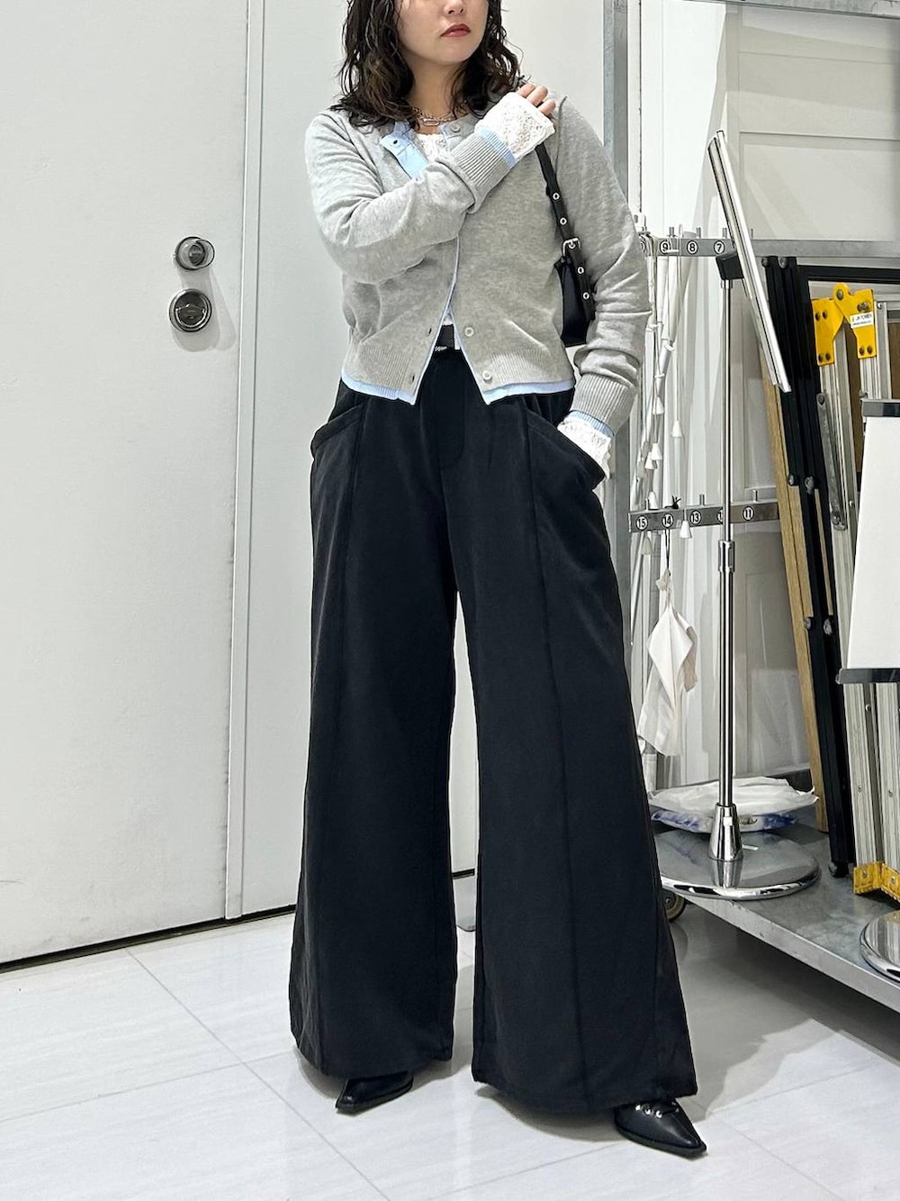 ブラック系のスウェットパンツ、グレー系のカーディガン/ボレロ、ホワイト系のTシャツ/カットソーを着用したレディースの冬コーディネートの3枚目の写真