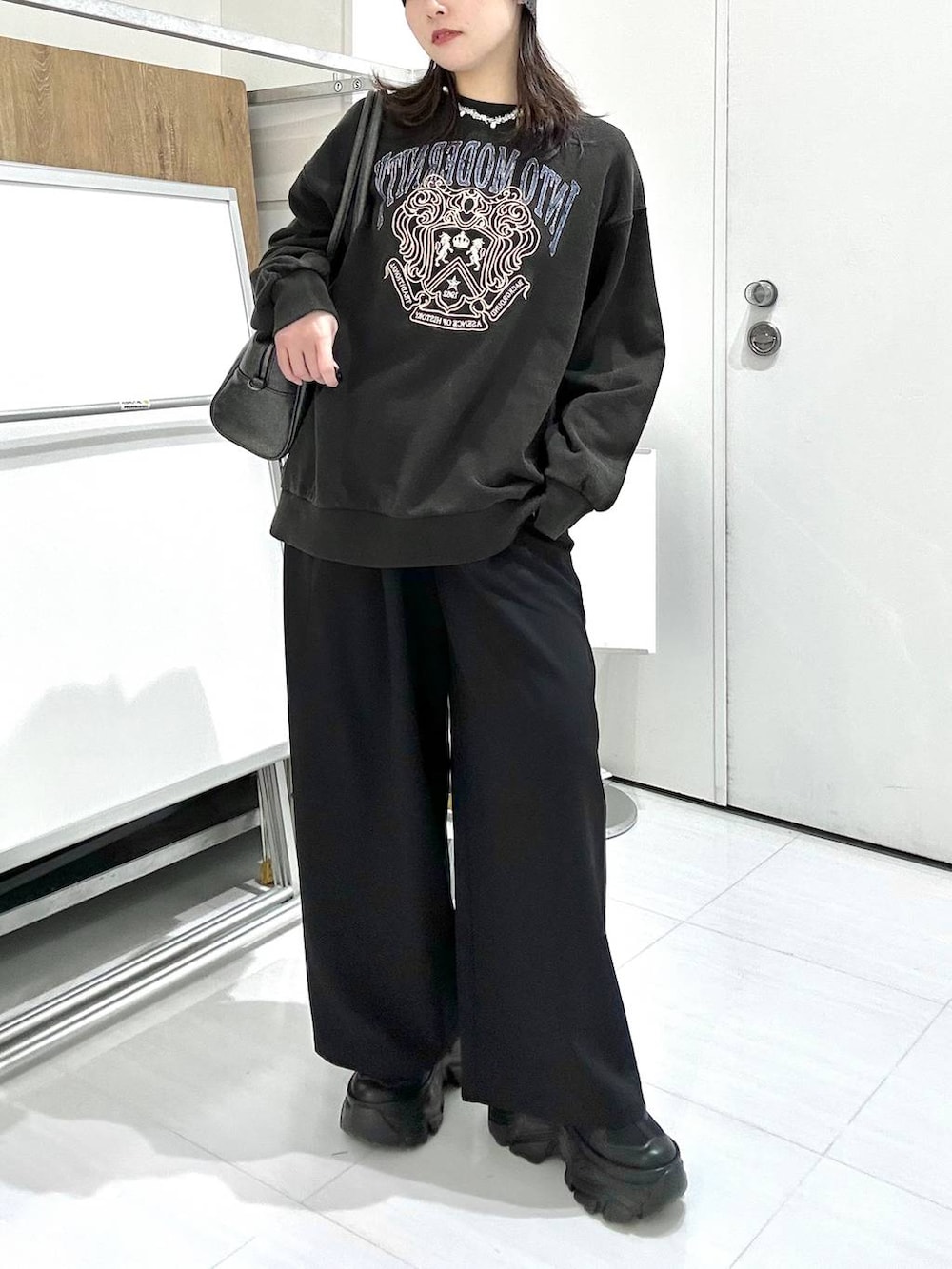 ブラック系のスニーカー、グレー系のボストンバッグ、グレー系のスウェットを着用したレディースの冬コーディネートの2枚目の写真