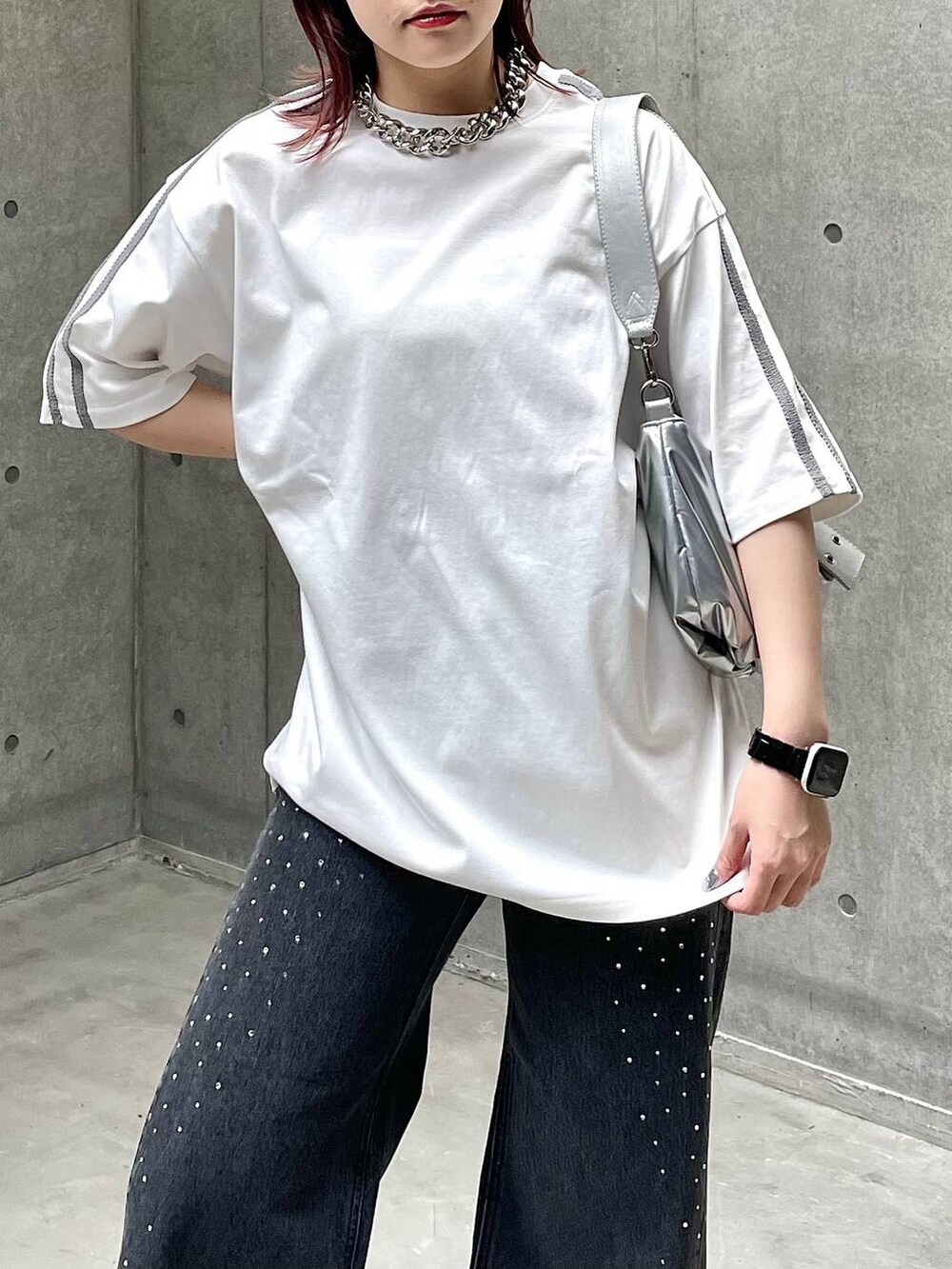 ブラック系のスニーカー、ホワイト系のTシャツ/カットソー、ブラック系のデニムパンツを着用したレディースの春コーディネートの3枚目の写真