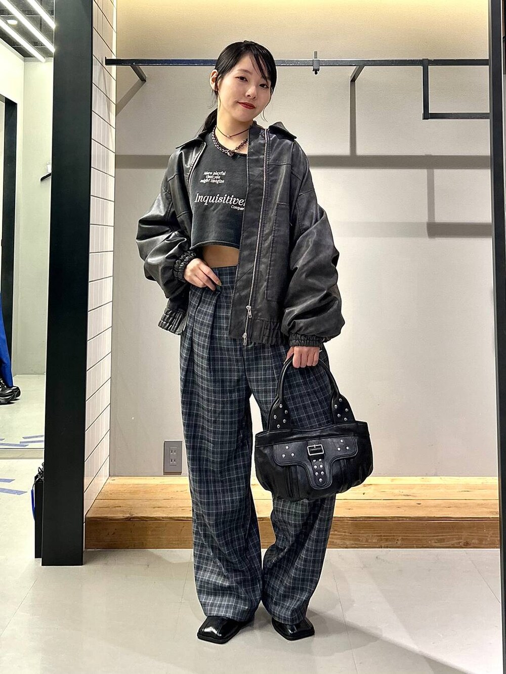 グレー系のブルゾン、ブラック系のブーツ、グレー系のスラックスを着用したレディースの秋コーディネートの3枚目の写真