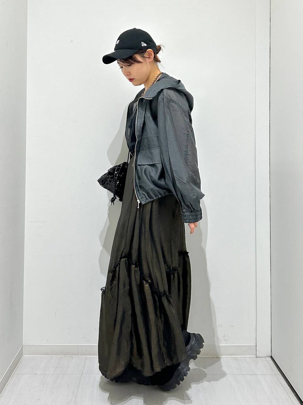 ブラック系のタンクトップ、ブラック系のスカート、グレー系のブルゾンを着用したレディースの春コーディネートの6枚目の写真