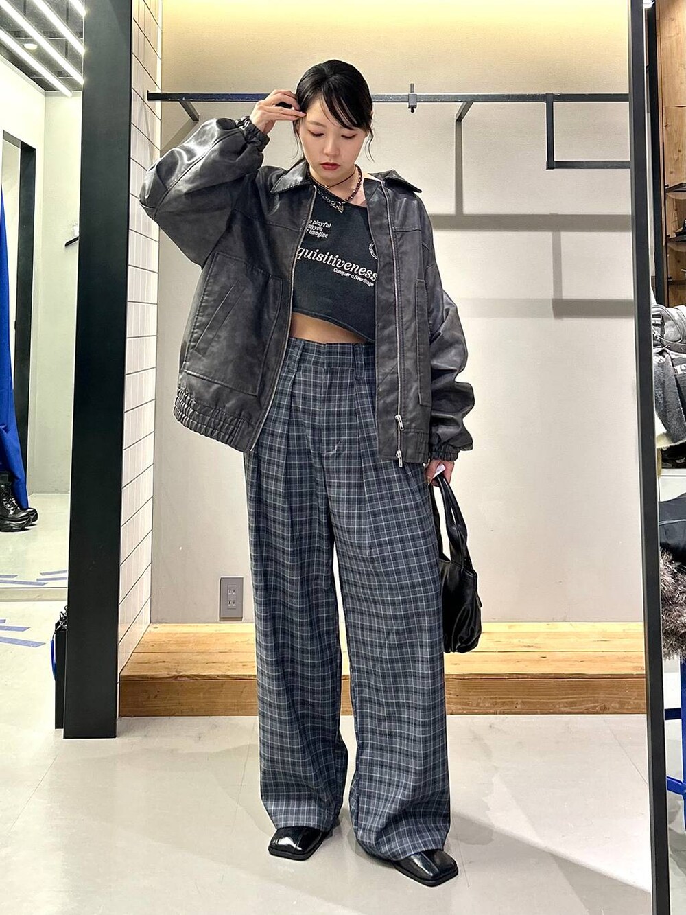 グレー系のブルゾン、ブラック系のブーツ、グレー系のスラックスを着用したレディースの秋コーディネートの8枚目の写真