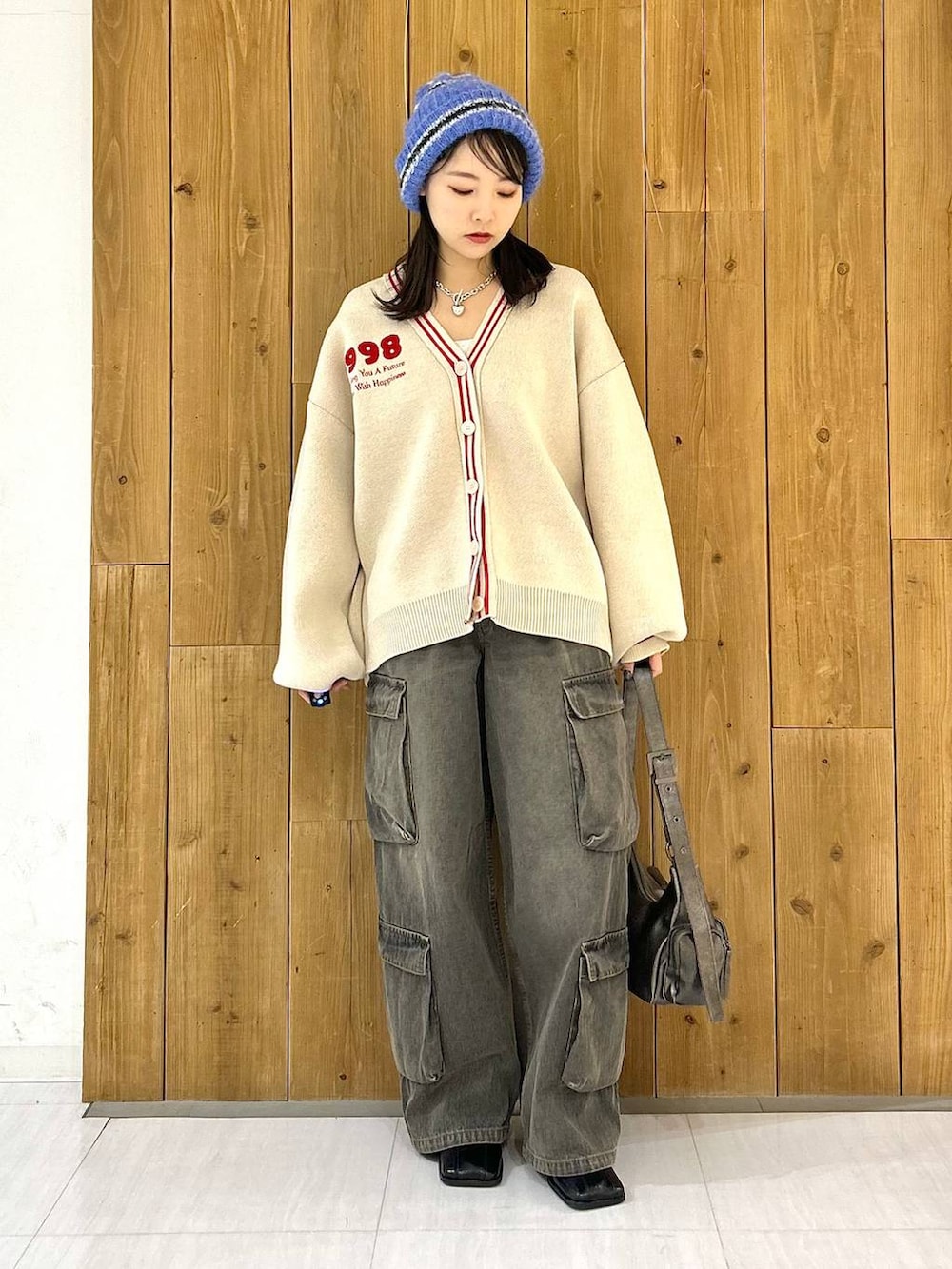 その他のショルダーバッグ、ブラック系のデニムパンツ、ベージュ系のカーディガン/ボレロを着用したレディースの冬コーディネートの2枚目の写真