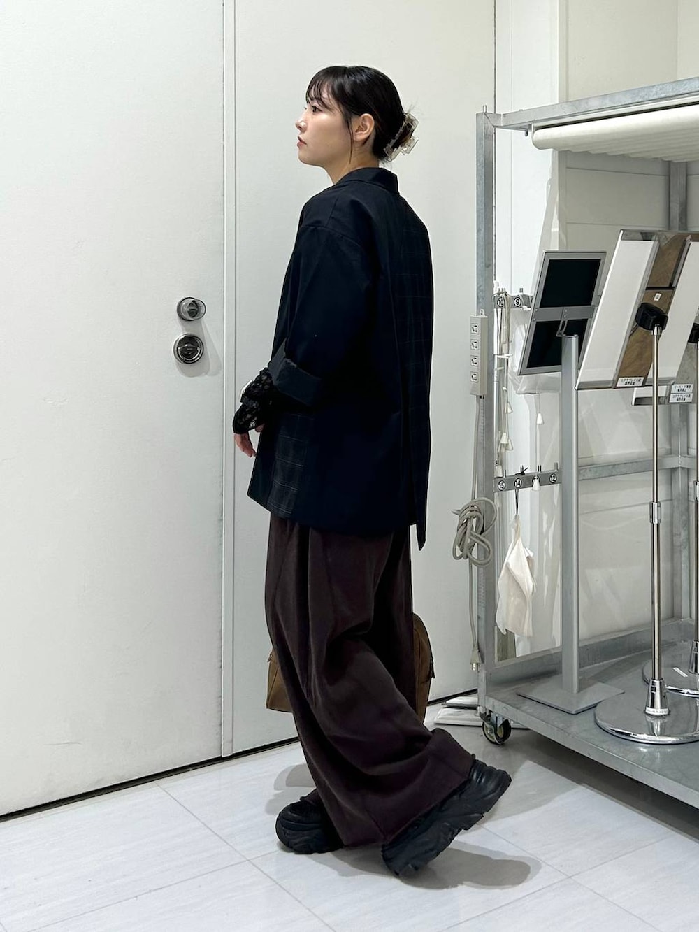 ベージュ系のボストンバッグ、ブラック系のスウェットパンツ、ブラック系のテーラードジャケットを着用したレディースの秋コーディネートの5枚目の写真