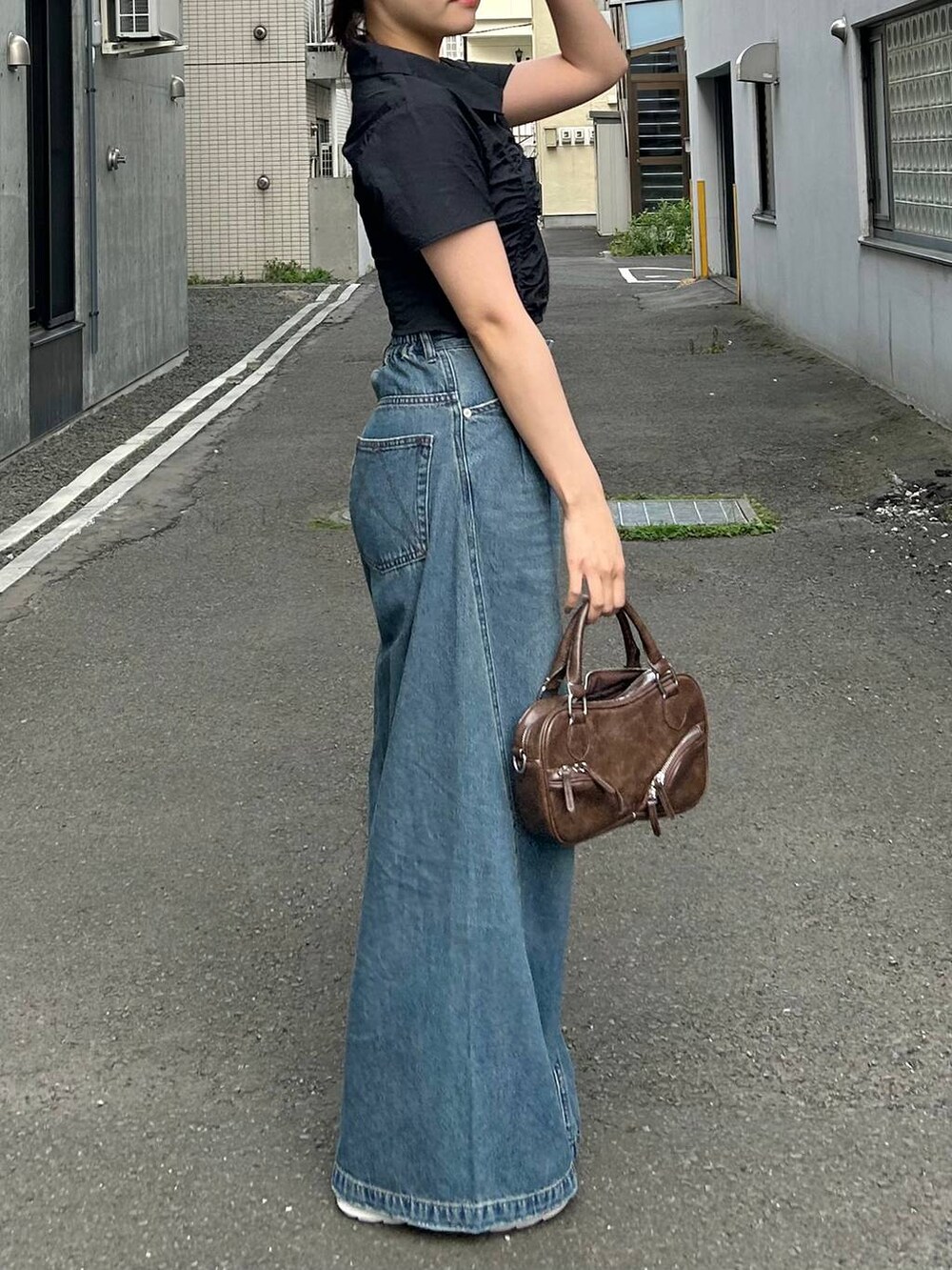 ブルー系のデニムパンツ、ブラック系のキャミソール、ブラック系のシャツ/ブラウスを着用したレディースの夏コーディネートの5枚目の写真