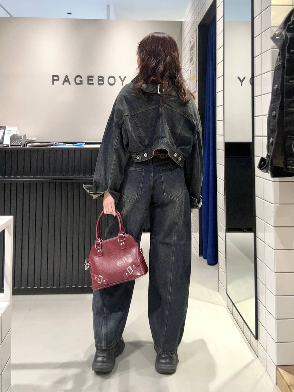 ブルー系のデニムパンツ、ブラック系のスニーカー、ブルー系のデニムジャケットを着用したレディースの秋コーディネートの5枚目の写真