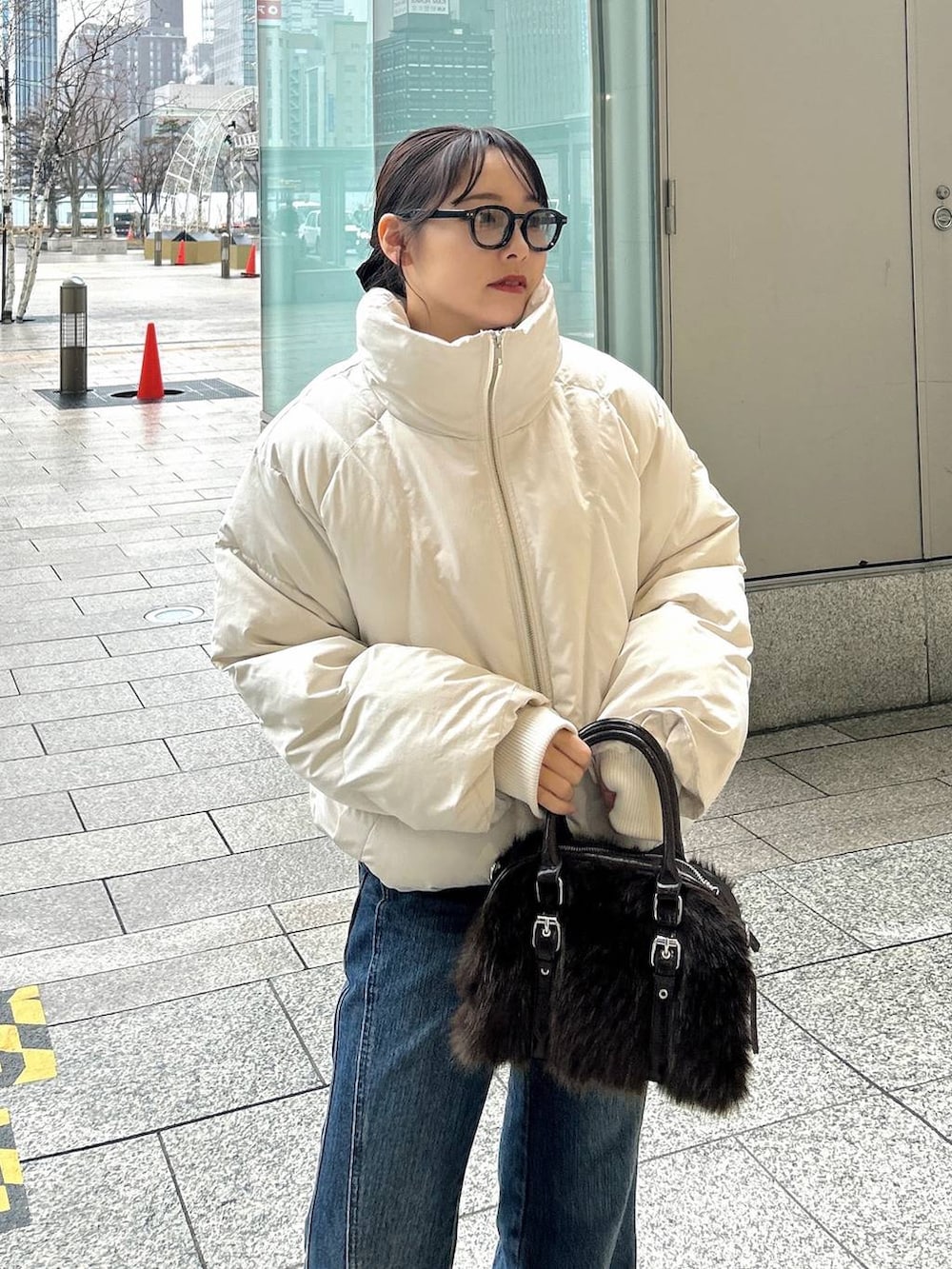 ブルー系のデニムパンツ、ホワイト系のブルゾン、ブラック系のブーツを着用したレディースの冬コーディネートの2枚目の写真