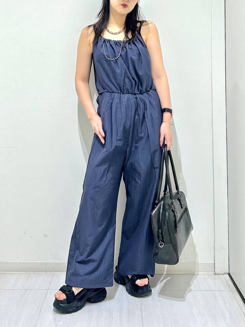 ブラック系のボストンバッグ、ブラック系のサンダル、ブラック系のキャミソールを着用したレディースの春コーディネートの3枚目の写真