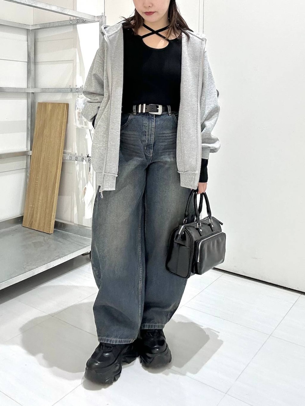 ブラック系のスニーカー、グレー系のパーカー、ブラック系のニット/セーターを着用したレディースの冬コーディネートの3枚目の写真