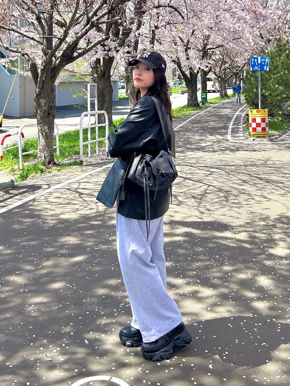 ブラック系のスニーカー、ブラック系のテーラードジャケット、グレー系のスウェットパンツを着用したレディースの春コーディネートの2枚目の写真