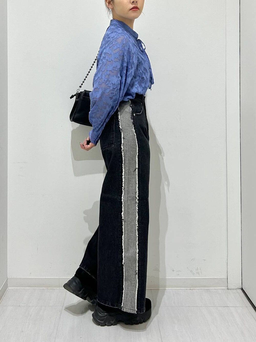 ブラック系のショルダーバッグ、ブラック系のデニムパンツ、ブルー系のシャツ/ブラウスを着用したレディースの春コーディネートの4枚目の写真