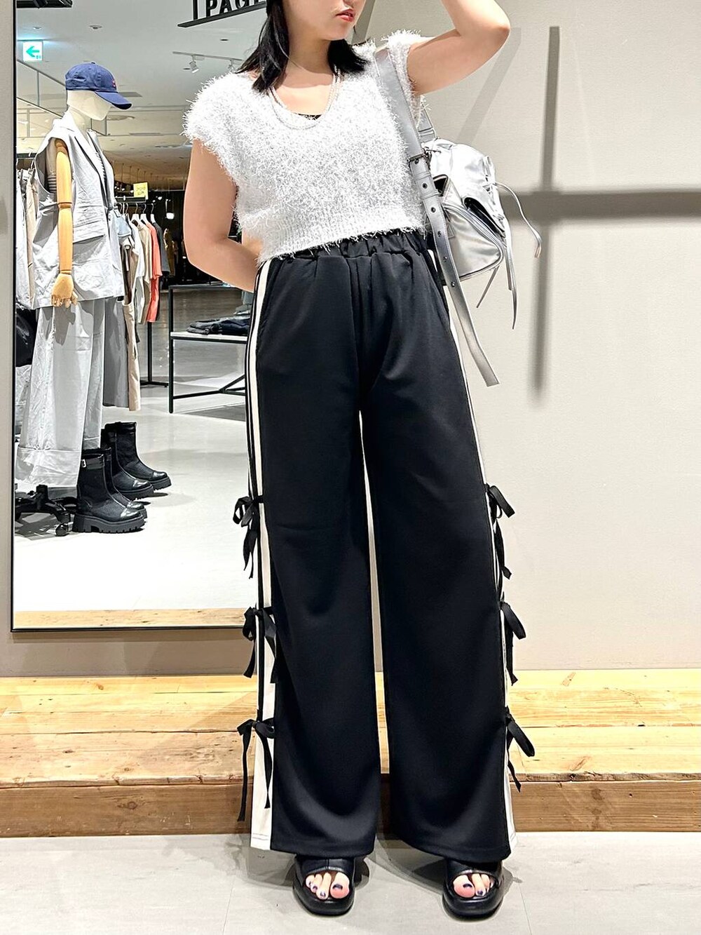 ブラック系のサンダル、ホワイト系のベスト、ブラック系のキャミソールを着用したレディースの夏コーディネートの7枚目の写真