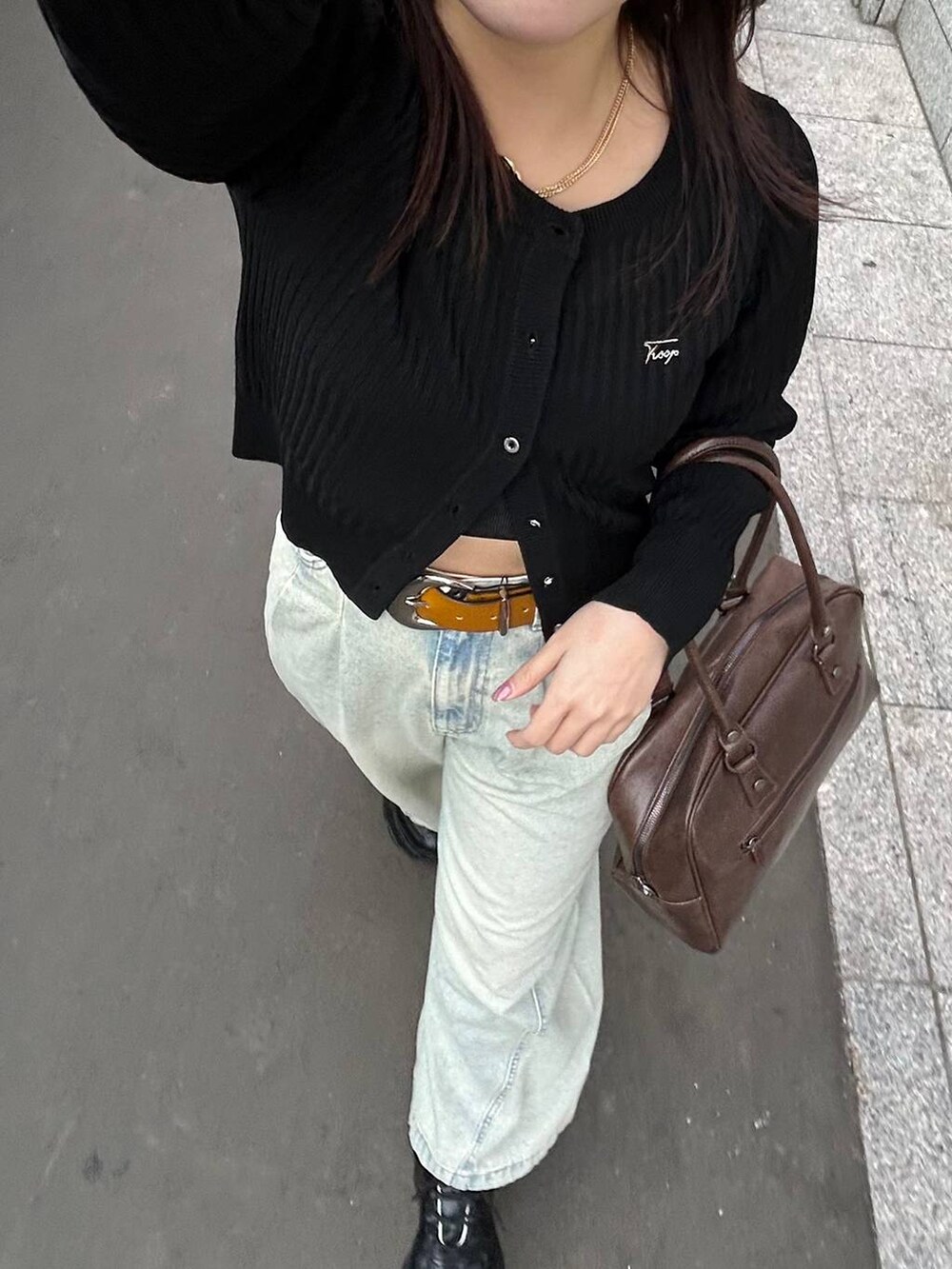 ブラック系のスニーカー、ブルー系のデニムパンツ、ブラウン系のボストンバッグを着用したレディースの夏コーディネートの8枚目の写真