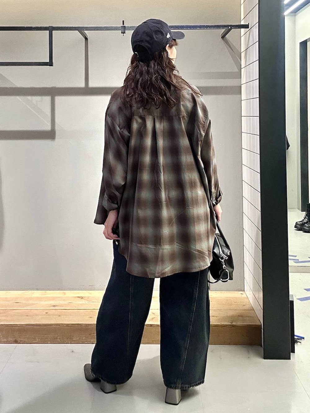 ブラック系のシャツ/ブラウス、ブルー系のデニムパンツ、ブラック系のショルダーバッグを着用したレディースの秋コーディネートの6枚目の写真