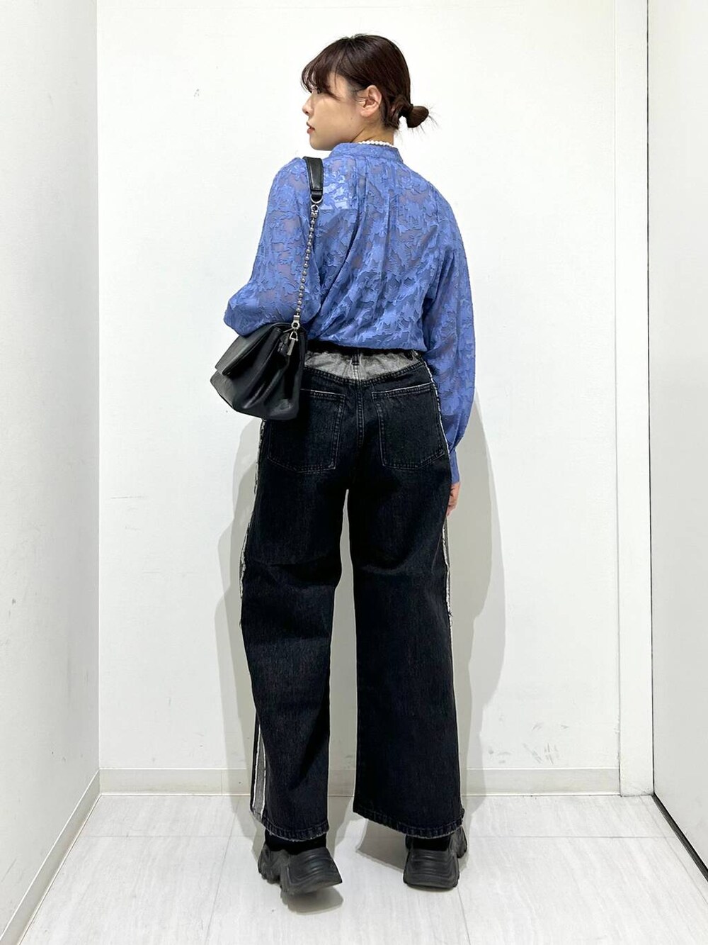 ブラック系のショルダーバッグ、ブラック系のデニムパンツ、ブルー系のシャツ/ブラウスを着用したレディースの春コーディネートの6枚目の写真