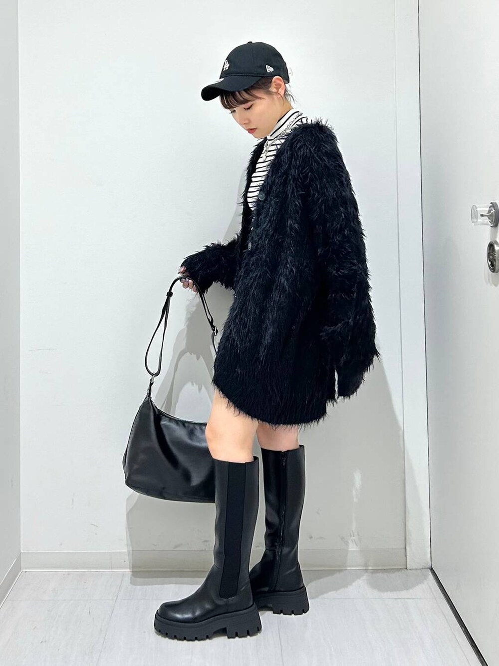 ブラック系のカーディガン/ボレロ、ブラック系のブーツ、ブラック系のショルダーバッグを着用したレディースの秋コーディネートの3枚目の写真