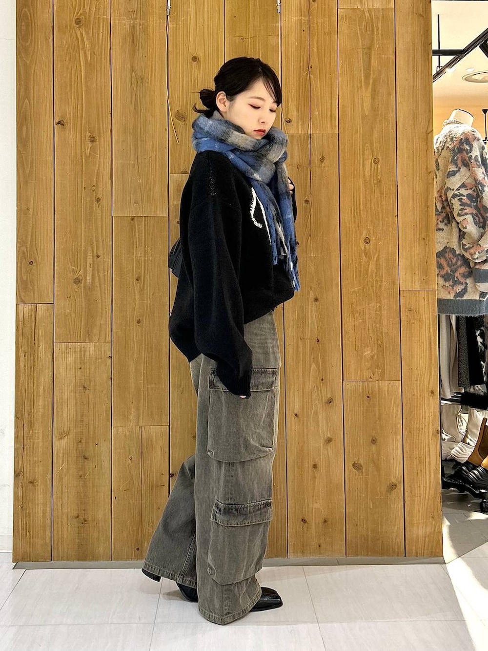 ブラック系のショルダーバッグ、ブラック系のニット/セーター、ブラック系のデニムパンツを着用したレディースの冬コーディネートの5枚目の写真