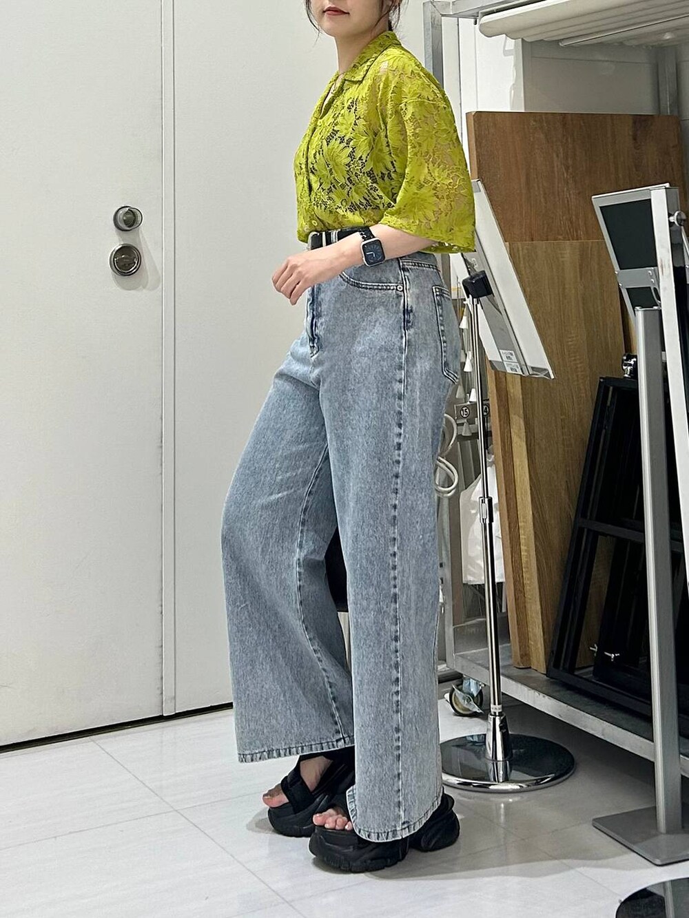 ブラック系のサンダル、ブラック系のキャミソール、ブルー系のデニムパンツを着用したレディースの夏コーディネートの6枚目の写真