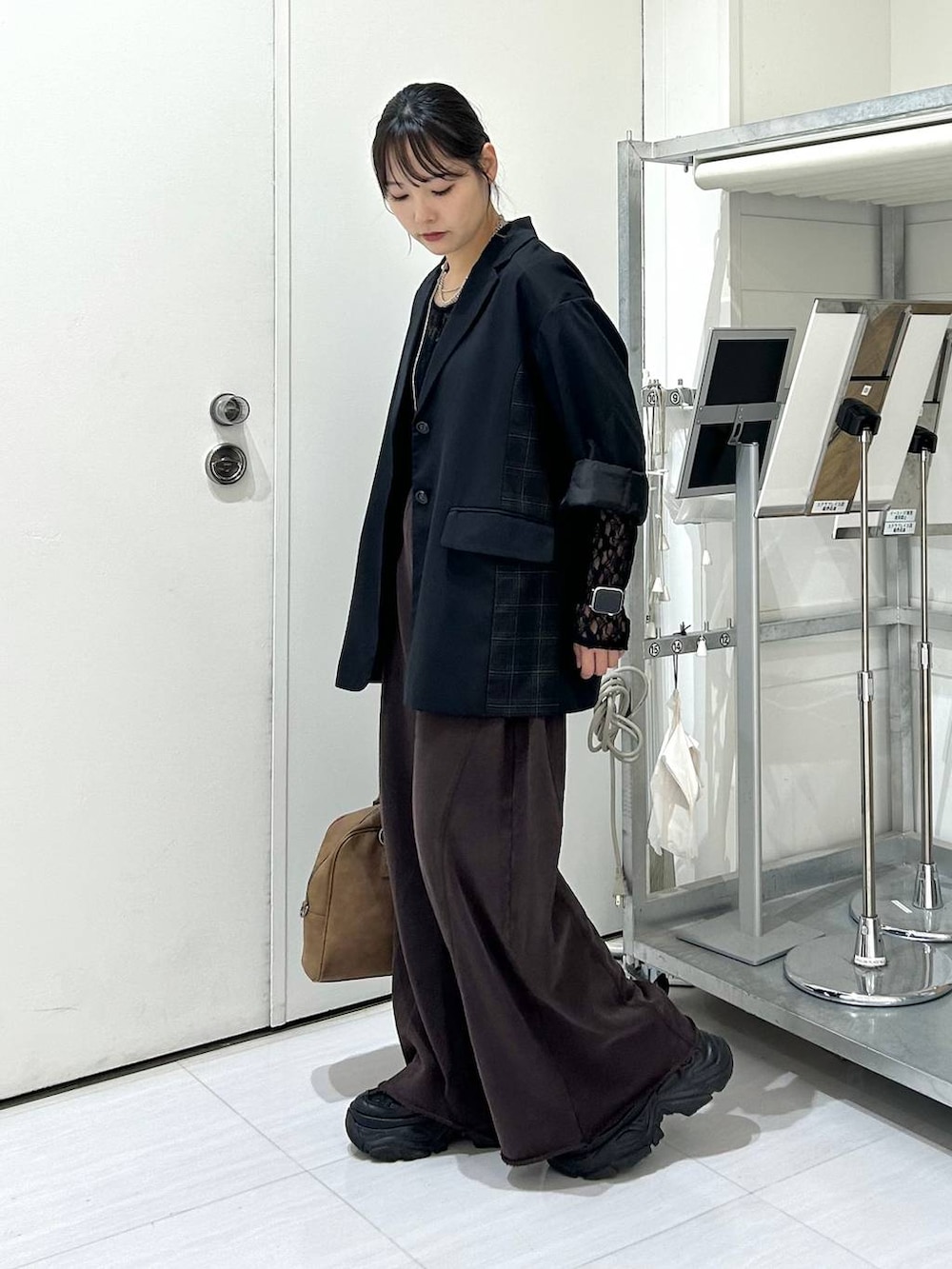 ベージュ系のボストンバッグ、ブラック系のスウェットパンツ、ブラック系のテーラードジャケットを着用したレディースの秋コーディネートの6枚目の写真