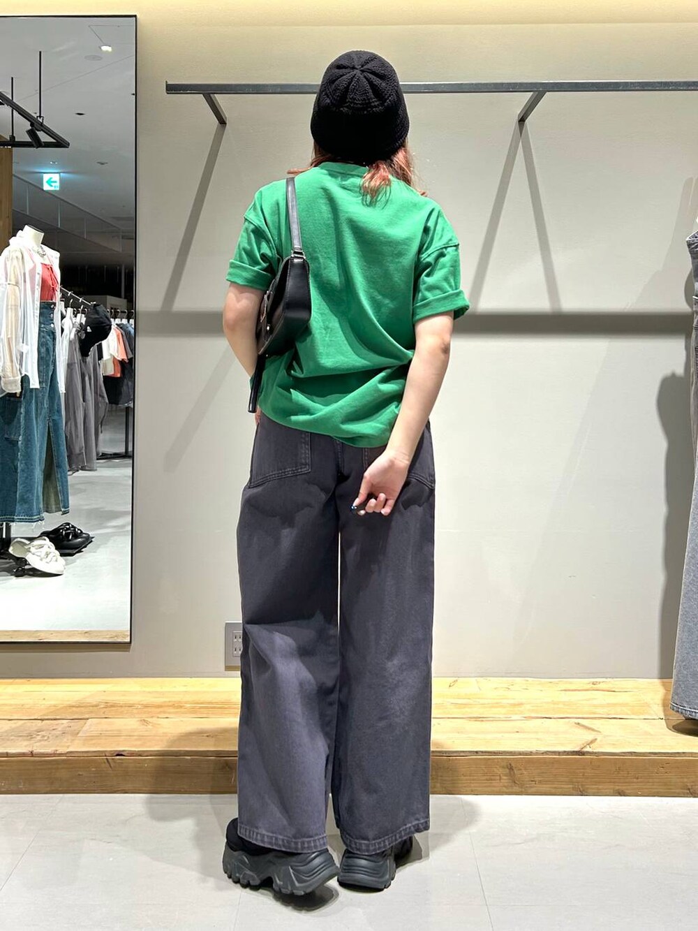ブラック系のハンドバッグ、グリーン系のTシャツ/カットソー、ブラック系のデニムパンツを着用したレディースの春コーディネートの4枚目の写真
