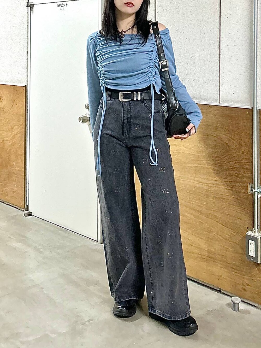 ブラック系のデニムパンツ、ブラック系のスニーカー、ブラック系のショルダーバッグを着用したレディースの春コーディネートの3枚目の写真