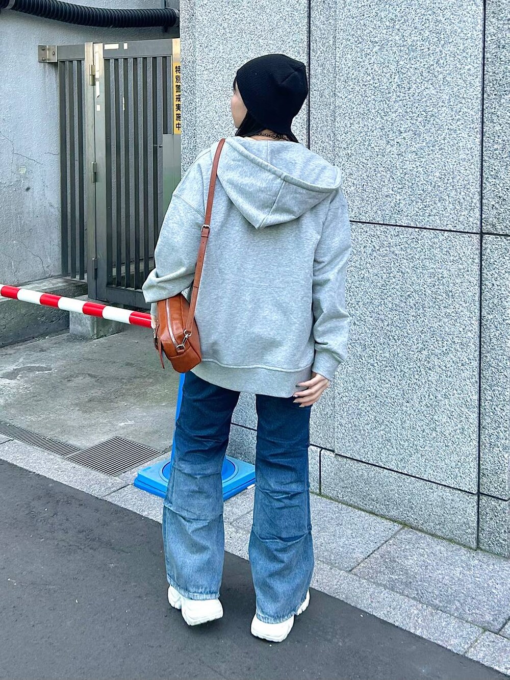 ブルー系のデニムパンツ、グレー系のパーカー、オレンジ系のTシャツ/カットソーを着用したレディースの春コーディネートの4枚目の写真