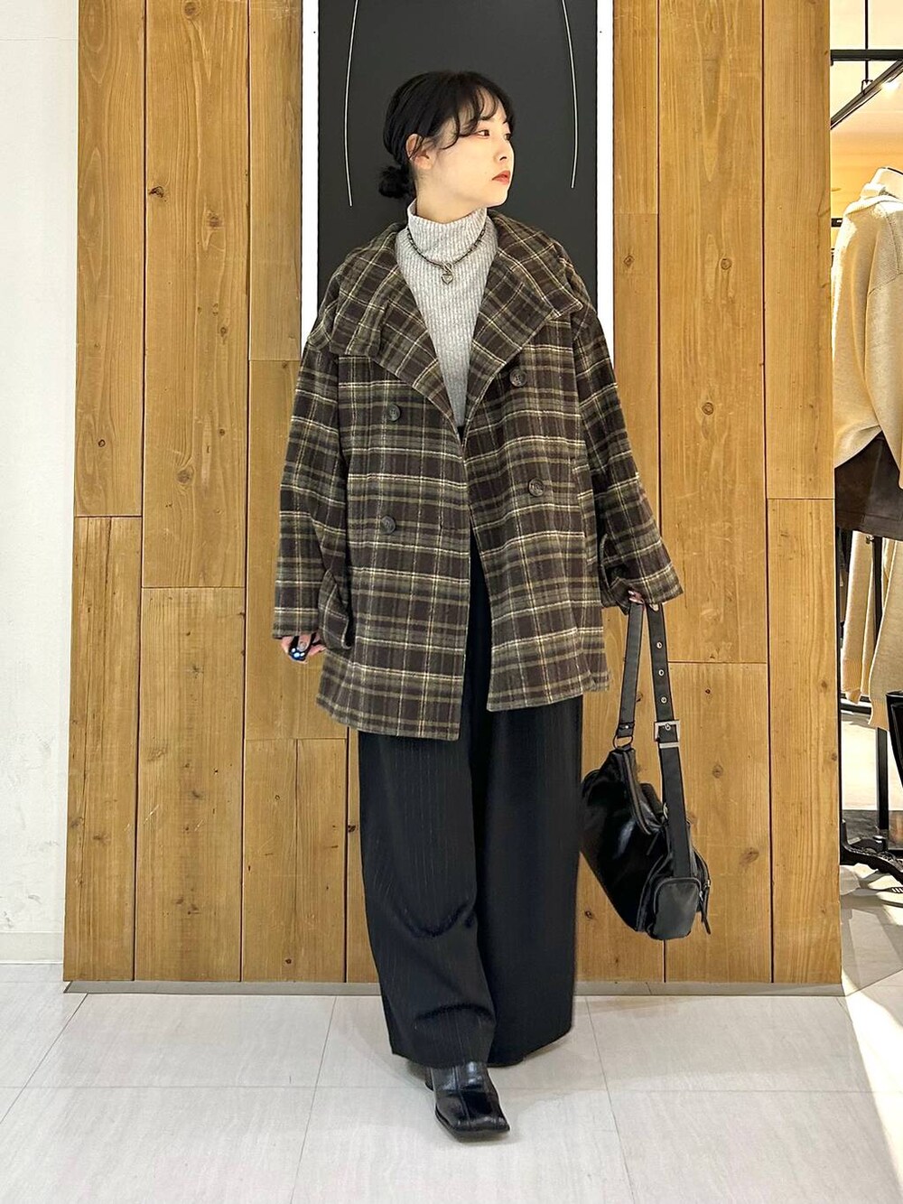 ブラウン系のテーラードジャケット、その他のショルダーバッグ、グレー系のTシャツ/カットソーを着用したレディースの冬コーディネートの2枚目の写真